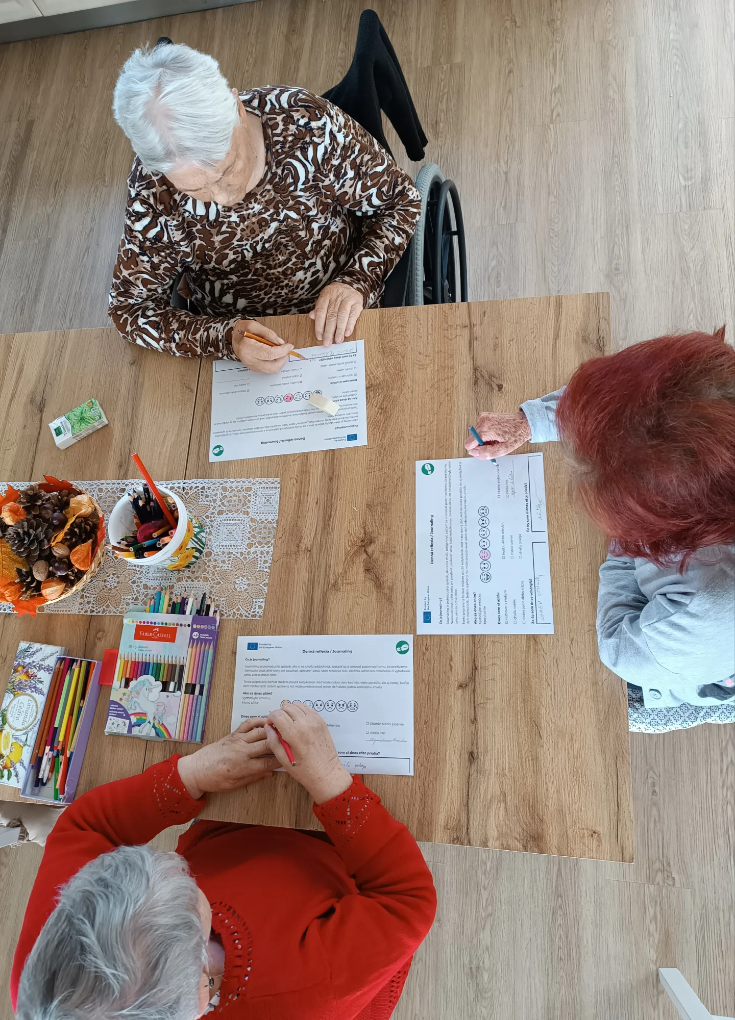 Tri seniorky v Centre soci&aacute;lnych služieb Johanka vypĺňaj&uacute; pracovn&eacute; listy zameran&eacute; na reflexiu pocitov a du&scaron;evn&uacute; pohodu.